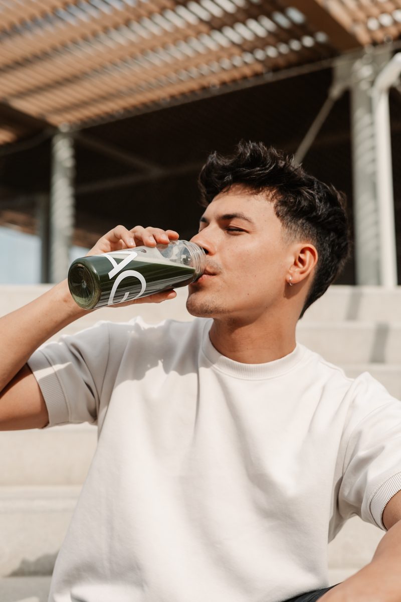Man drinking a green beverage