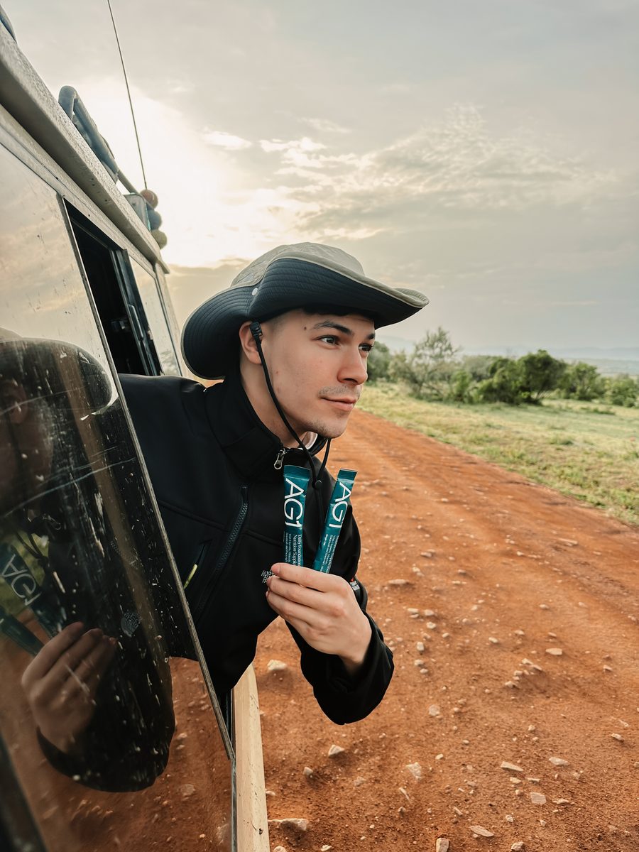 Man on safari holding AG1 sachets